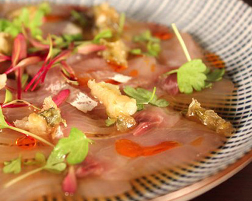 Kingfish belly carpaccio with chili oil and a sweet ginger and mirin sauce, topped with tempura jalapeno